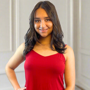 variant::Crimson Young woman wearing ecofiendly bamboo shtretch knit cami in red shown from waist up