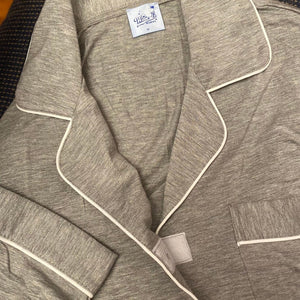 variant::grey  Close-up of a grey pajama top trimmed in white piping with Velcro closure.  variant::All