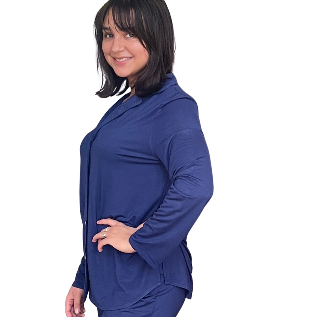 Woman with dark brown hair and her hand on her hip standing at a profile view.  She is wearing the Live-In Blue lenzing modal/ Bamboo pajama shirt with Velcro closure. Modal/bamboo is great at wicking moisture away and suitable for night sweats.